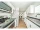Modern kitchen boasts stainless steel appliances, white cabinetry, and wood-look flooring at 5516 W Minnesota St, Indianapolis, IN 46241