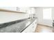 Bright kitchen featuring white cabinets, stainless steel sink, and wood-look flooring at 5516 W Minnesota St, Indianapolis, IN 46241