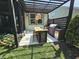 An outdoor kitchen and bar with seating beneath a pergola overlook the landscaped lawn at 5686 Ellie Ct, Noblesville, IN 46062