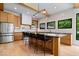 Bright kitchen featuring custom cabinets, stainless steel appliances, a large island, and backyard view at 631 1St Nw Ave, Carmel, IN 46032