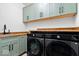 This laundry room has modern washer and dryer units and ample cabinet space at 631 1St Nw Ave, Carmel, IN 46032