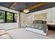 Bright main bedroom featuring a crystal chandelier, wood beams, and a large window providing natural light at 631 1St Nw Ave, Carmel, IN 46032