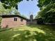 Brick home showcasing a well-maintained lawn and mature trees in a serene backyard setting at 6519 Creekside Ln, Indianapolis, IN 46220