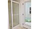 Bathroom features a shower with translucent doors and a view of an enclosed, green space at 6519 Creekside Ln, Indianapolis, IN 46220