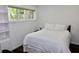 Bright bedroom featuring a white bed, and built-in shelves with natural light streaming through the window at 6519 Creekside Ln, Indianapolis, IN 46220