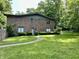 Well-maintained two-story brick building with a green lawn and mature trees surrounding it at 6519 Creekside Ln, Indianapolis, IN 46220