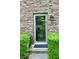 Charming front door with glass, set in a brick facade and flanked by manicured bushes at 6519 Creekside Ln, Indianapolis, IN 46220