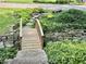 Charming front yard featuring a decorative wooden bridge and lush landscaping at 6519 Creekside Ln, Indianapolis, IN 46220