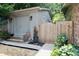 Exterior view of a storage shed or detached garage with a wooden gate and landscaped surroundings at 6519 Creekside Ln, Indianapolis, IN 46220
