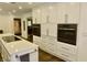 Spacious kitchen featuring white cabinetry, stainless steel appliances, and an island with seating and countertops at 6519 Creekside Ln, Indianapolis, IN 46220