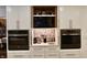 Modern kitchen with hidden appliance cabinet, updated backsplash, white cabinetry, and stainless steel appliances at 6519 Creekside Ln, Indianapolis, IN 46220