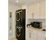 This laundry room features a stacked washer and dryer, as well as white cabinets and light countertops at 6519 Creekside Ln, Indianapolis, IN 46220