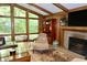 Relaxing living room with wood paneling, brick fireplace, and large windows at 6519 Creekside Ln, Indianapolis, IN 46220