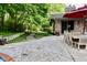 Back patio area adjacent to the pool featuring a stone walkway and abundant foliage at 6519 Creekside Ln, Indianapolis, IN 46220