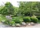 An inviting street view showcases the lush landscaping, mature trees, and attractive mailbox with the house number at 6519 Creekside Ln, Indianapolis, IN 46220