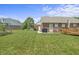 Spacious backyard featuring lush green grass, a swing set, and brick home at 6529 Lakesedge Dr, Indianapolis, IN 46237