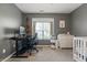 Bedroom offering a workspace, acoustic guitar, and white baby furniture, perfect for new parents at 6529 Lakesedge Dr, Indianapolis, IN 46237