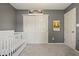 Cozy Bedroom features grey walls, white trim, and a white crib, creating a soothing atmosphere at 6529 Lakesedge Dr, Indianapolis, IN 46237