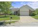 Charming brick and vinyl home featuring an attached two-car garage, landscaped lawn, and concrete driveway at 6529 Lakesedge Dr, Indianapolis, IN 46237