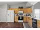 Spacious kitchen featuring wood cabinets, white appliances, and a modern design at 6529 Lakesedge Dr, Indianapolis, IN 46237