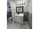 Updated bathroom featuring marble floors, gray wainscotting, and modern vanity with black hardware at 7492 Country Brook Dr, Indianapolis, IN 46260