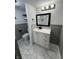 Updated bathroom featuring marble floors, gray wainscotting, and modern vanity with black hardware at 7492 Country Brook Dr, Indianapolis, IN 46260
