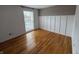 Bright bedroom with hardwood floors, white wainscoting, and a large window at 7492 Country Brook Dr, Indianapolis, IN 46260