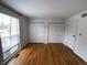 Spacious bedroom featuring hardwood floors, window, two closets and neutral paint at 7492 Country Brook Dr, Indianapolis, IN 46260