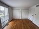 Bright bedroom featuring hardwood floors, a large window, and closet space at 7492 Country Brook Dr, Indianapolis, IN 46260