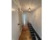 Hallway with wood floors, black iron railing, and modern lighting fixture at 7492 Country Brook Dr, Indianapolis, IN 46260
