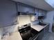 Modern kitchen with granite countertops, stainless steel appliances, and gray cabinetry at 7492 Country Brook Dr, Indianapolis, IN 46260