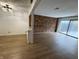 Spacious living room with wood floors, brick accent wall, and sliding glass doors at 7492 Country Brook Dr, Indianapolis, IN 46260