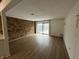 Bright living room featuring a brick wall, hardwood floors, and sliding glass doors at 7492 Country Brook Dr, Indianapolis, IN 46260