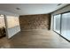 Open-concept living room featuring hardwood floors, brick accent wall, and large windows at 7492 Country Brook Dr, Indianapolis, IN 46260