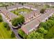 Aerial view of brick townhouses surrounding a pond with a fountain and manicured green spaces in a community at 755 Ivy Ln, Carmel, IN 46032