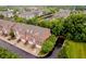 An aerial view showcases brick townhouses near a pond and canal, surrounded by lush greenery and a community feel at 755 Ivy Ln, Carmel, IN 46032