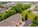 An aerial view shows brick townhouses with green spaces, mature trees and landscaping in a desirable neighborhood at 755 Ivy Ln, Carmel, IN 46032