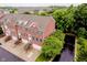 Brick townhouses with attached garages offer manicured lawns and mature trees, providing a serene neighborhood setting at 755 Ivy Ln, Carmel, IN 46032