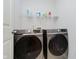 Laundry room with modern Samsung washer and dryer, wire shelving, and overhead lighting at 755 Ivy Ln, Carmel, IN 46032