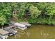 An aerial view of a lakefront house surrounded by lush trees and dock with several boats, offering serenity at 8133 Lower Bay Ln, Indianapolis, IN 46236