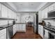 A bright kitchen featuring white cabinets, modern appliances, and open access to dining area at 8133 Lower Bay Ln, Indianapolis, IN 46236