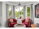 Sitting area with bay window, red chairs, views of lake, and an ottoman at 8133 Lower Bay Ln, Indianapolis, IN 46236