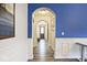 View of hallway with an archway, white trim, luxury vinyl flooring, and tastefully decorated blue accent wall at 8176 Crumwell Dr, Avon, IN 46123