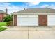 Attached two-car garage showcasing a brick facade and white doors at 8436 E 56Th St, Indianapolis, IN 46216