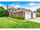 Backyard featuring lush green grass, a brick home, and detached three-car garage at 8436 E 56Th St, Indianapolis, IN 46216