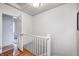 Hallway with gleaming wood floors, white walls, and an open doorway leading to a bathroom at 8436 E 56Th St, Indianapolis, IN 46216
