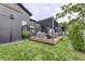 Landscaped backyard featuring a black home with a wood deck and a metal pergola at 8695 Morgan Dr, Fishers, IN 46038