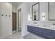 Bright bathroom featuring double sink vanity with custom cabinets and modern lighting fixtures and a walk-in closet at 8695 Morgan Dr, Fishers, IN 46038