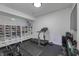 Home gym featuring a treadmill, exercise equipment, mirrored wall, a large storage unit, and rubber flooring at 8695 Morgan Dr, Fishers, IN 46038