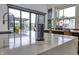 Modern kitchen featuring a marble countertop island with a pop-up outlet and a view of the backyard through sliding doors at 8695 Morgan Dr, Fishers, IN 46038